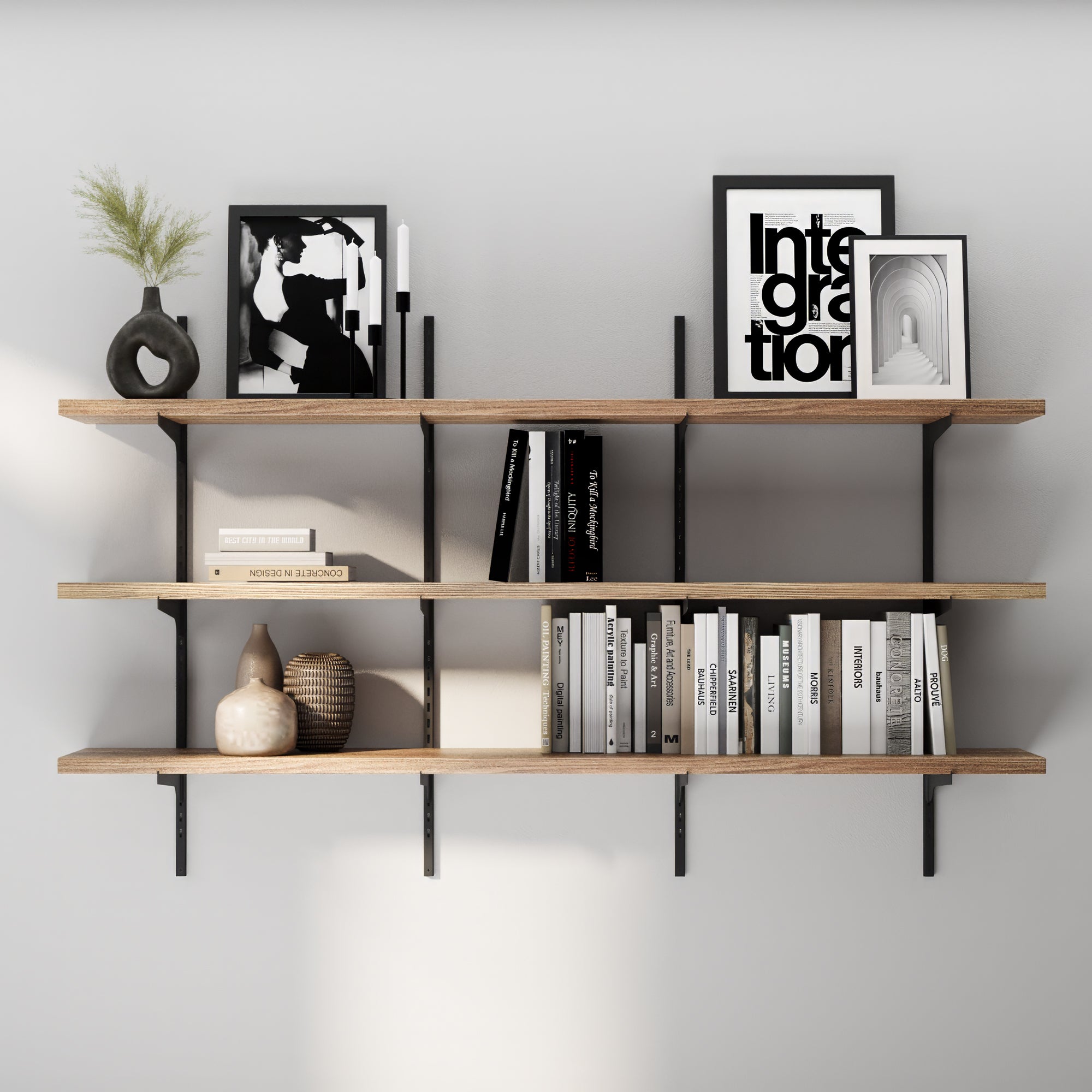 3 tier versatile shelving unit with books, decorative items, and framed pictures against a gray wall.