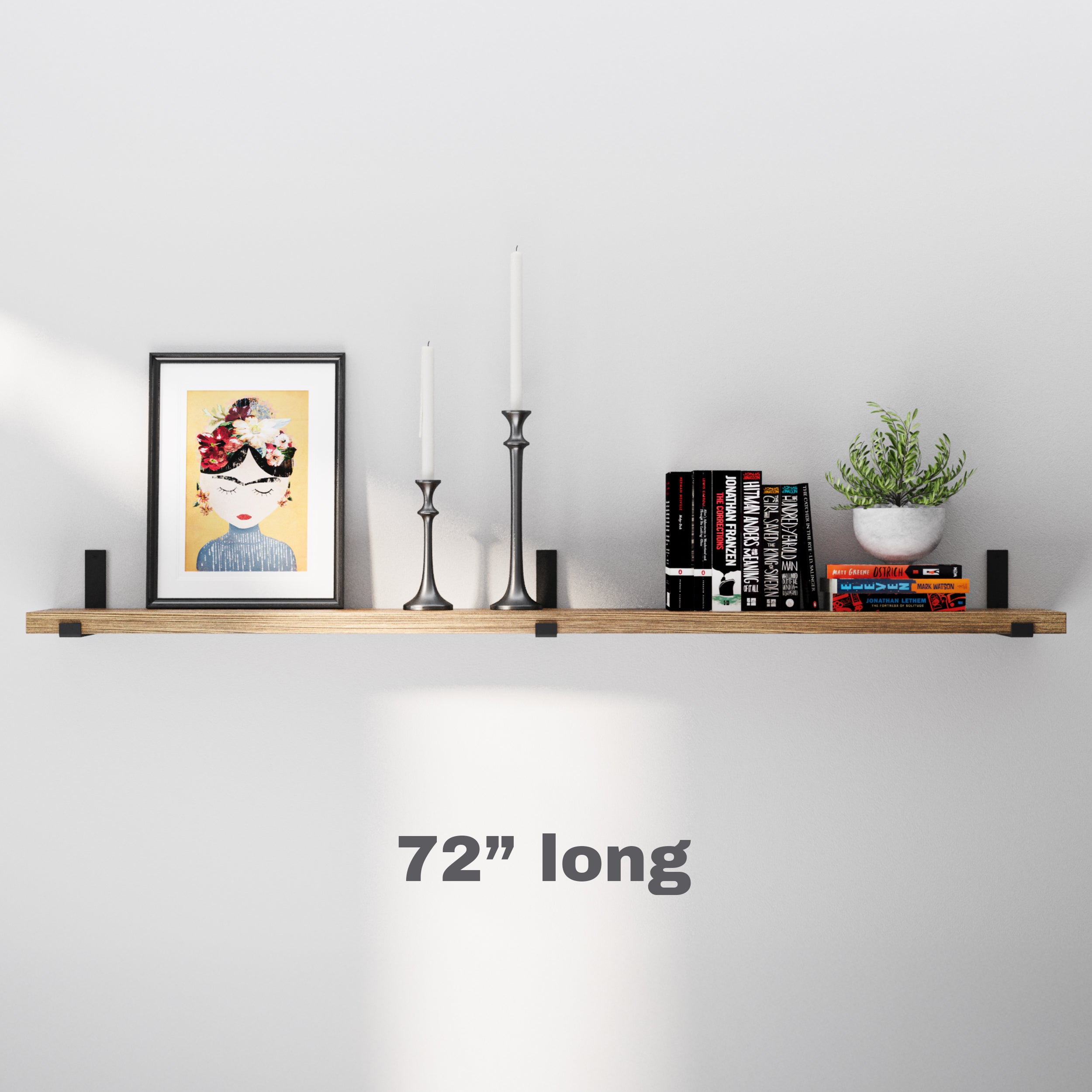 An extra long shelf elegantly showcases books, candles, and plants, perfect for filling large wall spaces with organized, stylish decor.