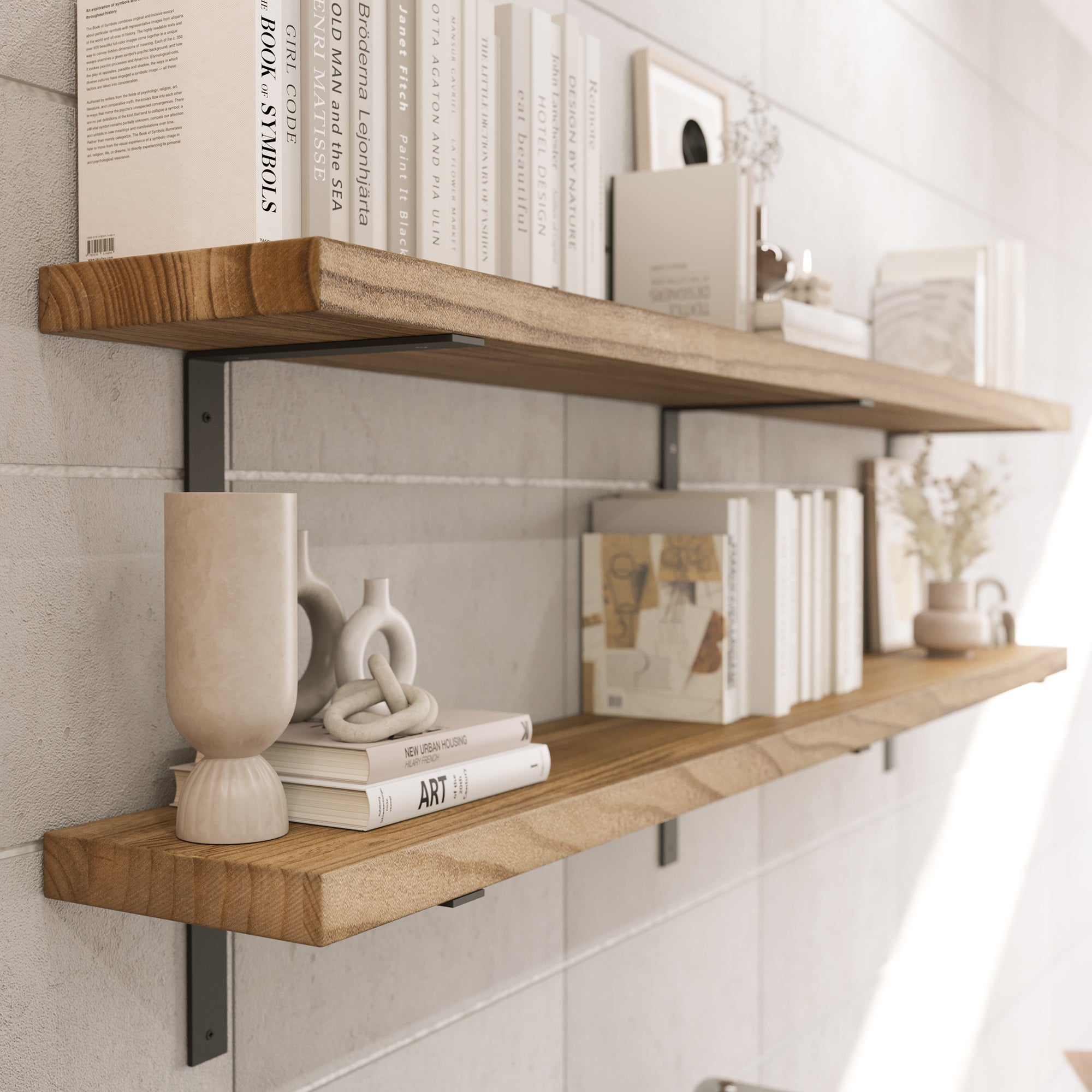 The image shows two wooden wall shelves with black metal brackets. They hold books and decor items like vases and artwork, creating a stylish, organized space against a light gray wall.