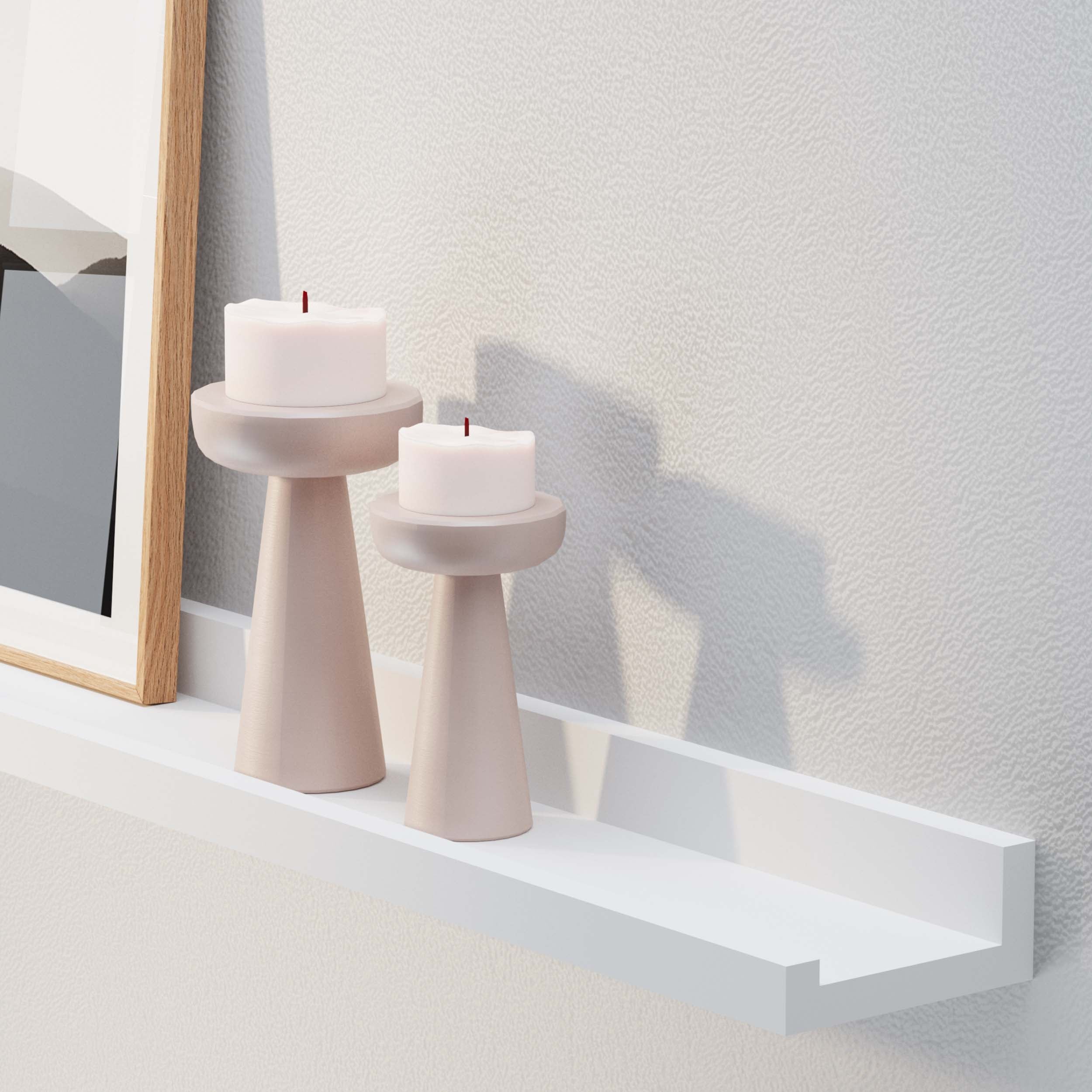 Two pink candle holders with white candles on a white shelf for wall against a white textured-wall.