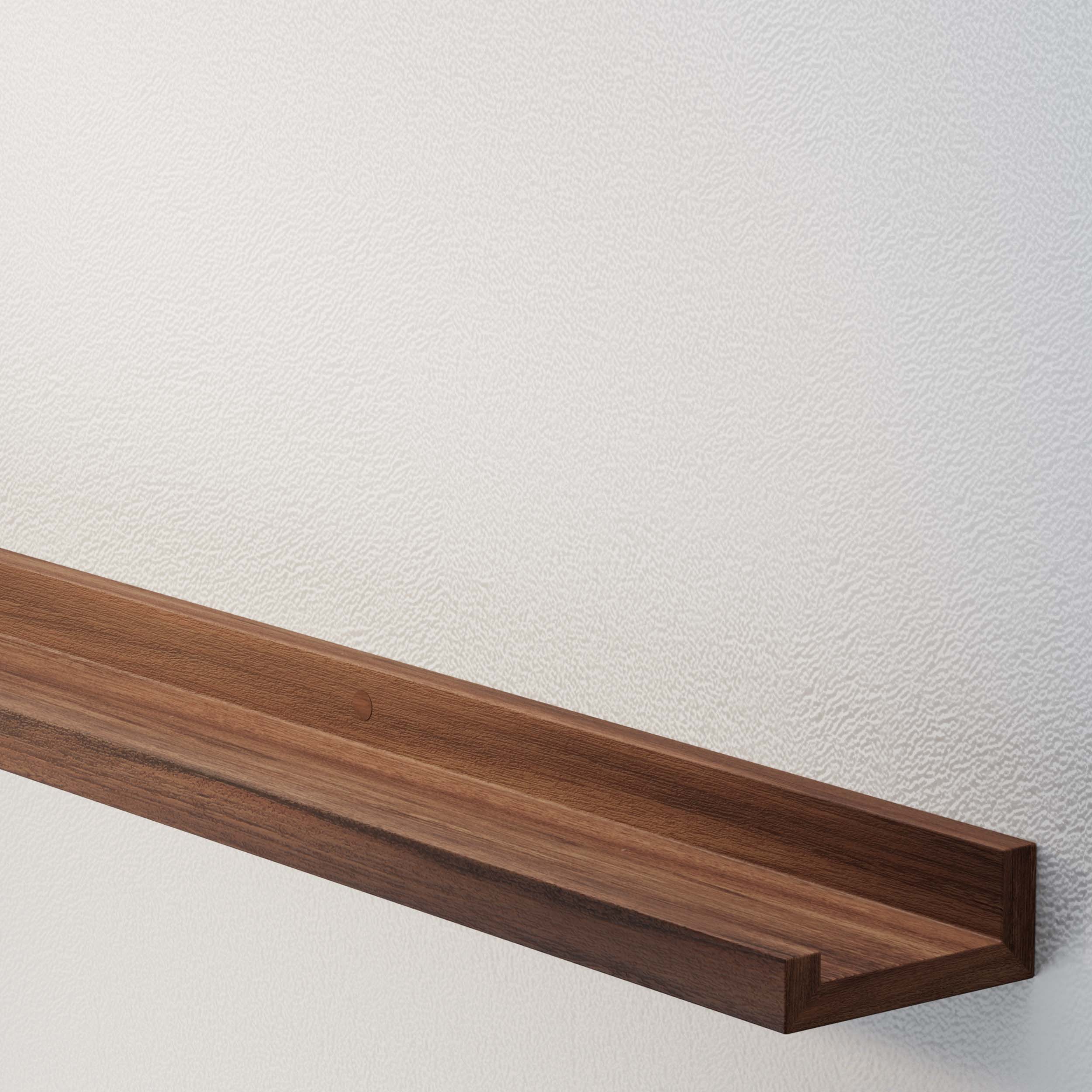 An empty walnut wall shelf against a textured wall, highlighting the shelf's sleek design and wood grain finish.