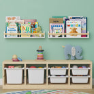 Two white book shelves for kids room filled with children's books and toys, mounted on a mint green wall above a wooden storage unit with white bins and colorful toys, creating a playful and organized children's room.