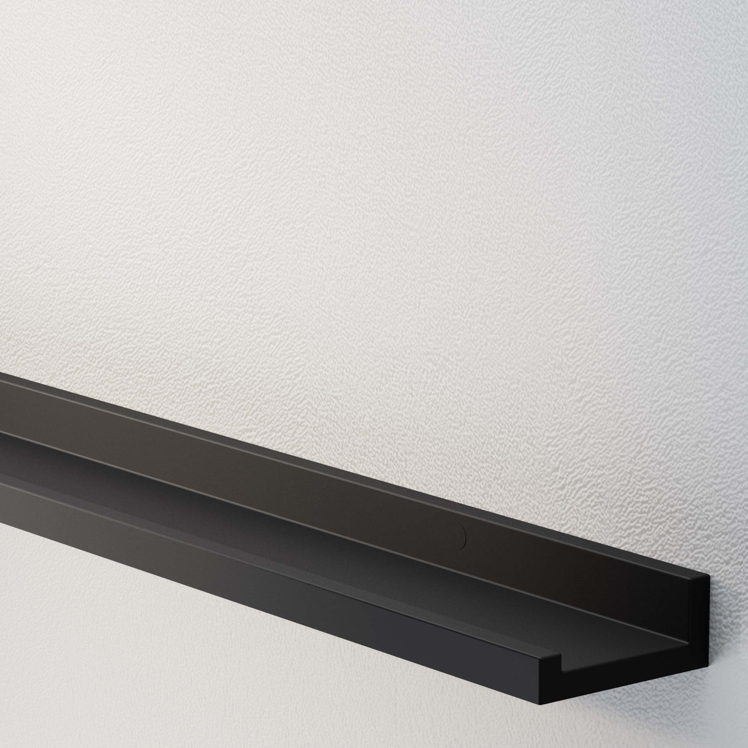 An angled view of an empty black wall shelf on a textured white wall.