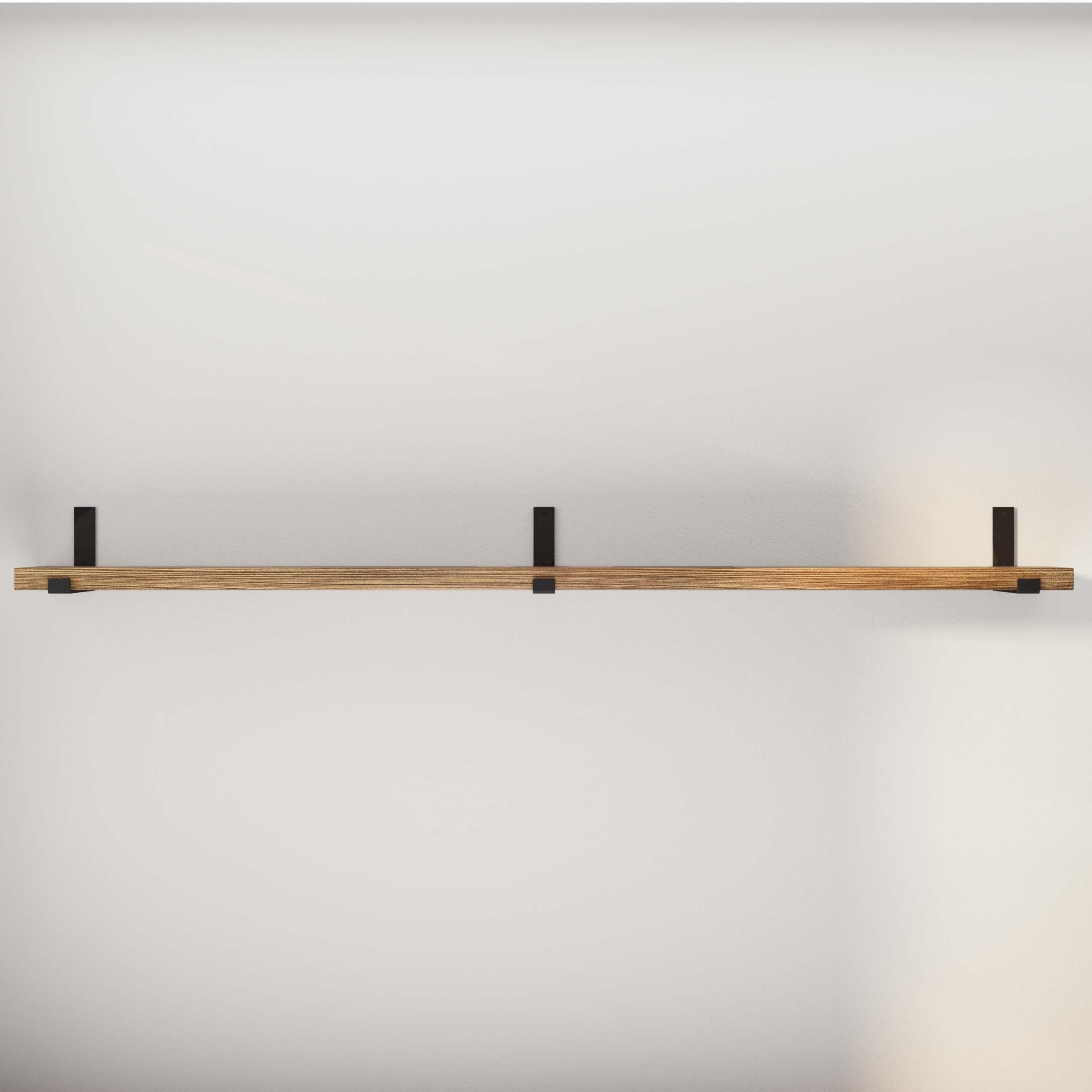 An empty wooden shelf mounted on a white wall.