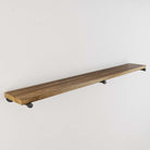 An empty rustic long floating shelf with a dark wood finish, focusing on the shelf itself without any decorations, showing the clean lines and the texture of the wood.