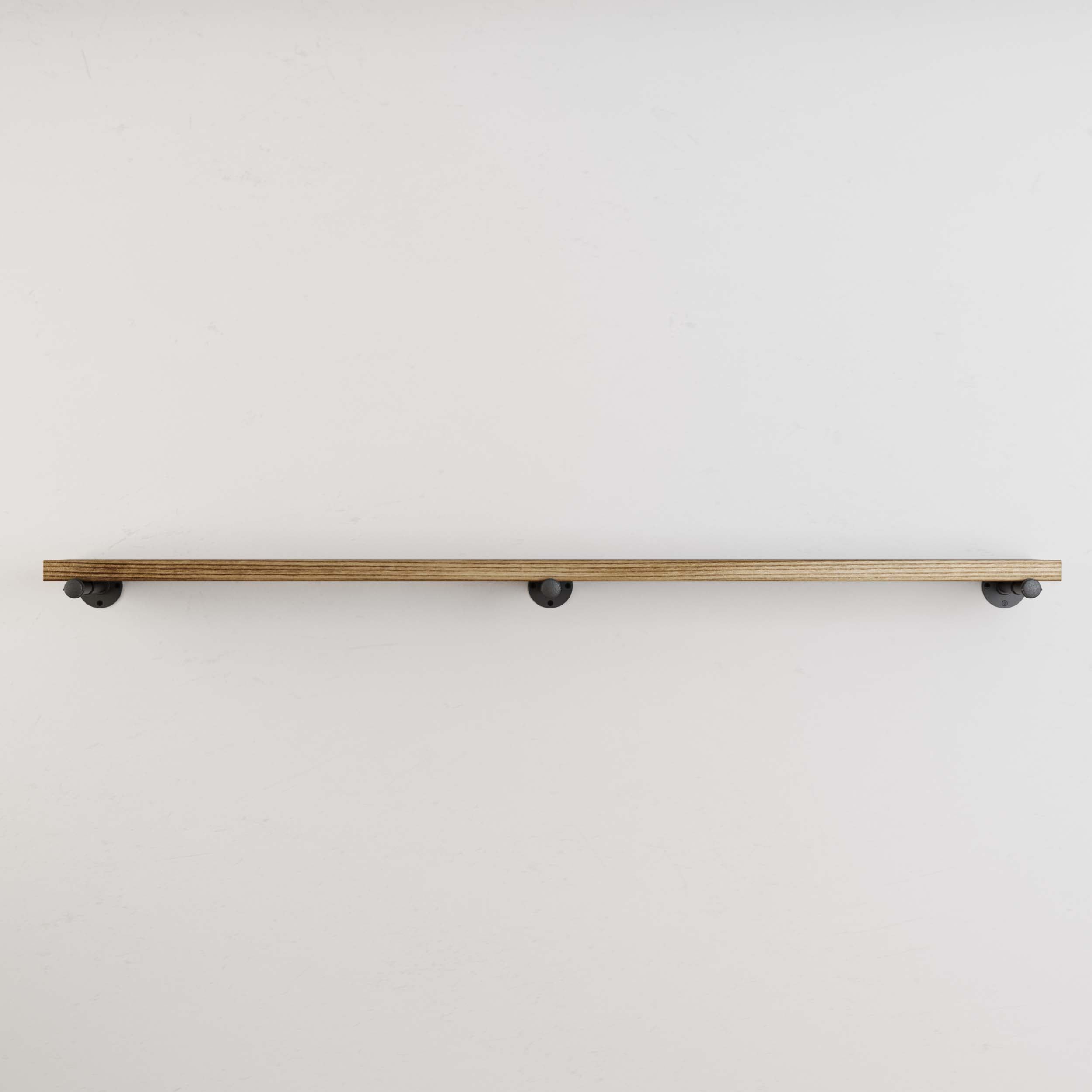 A minimalist view of the long pipe shelf, showing it mounted on the wall with black metal brackets, emphasizing the simplicity and modern design.