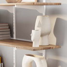 Hanging shelves for wall decor with decorative vases and books against a neutral wall