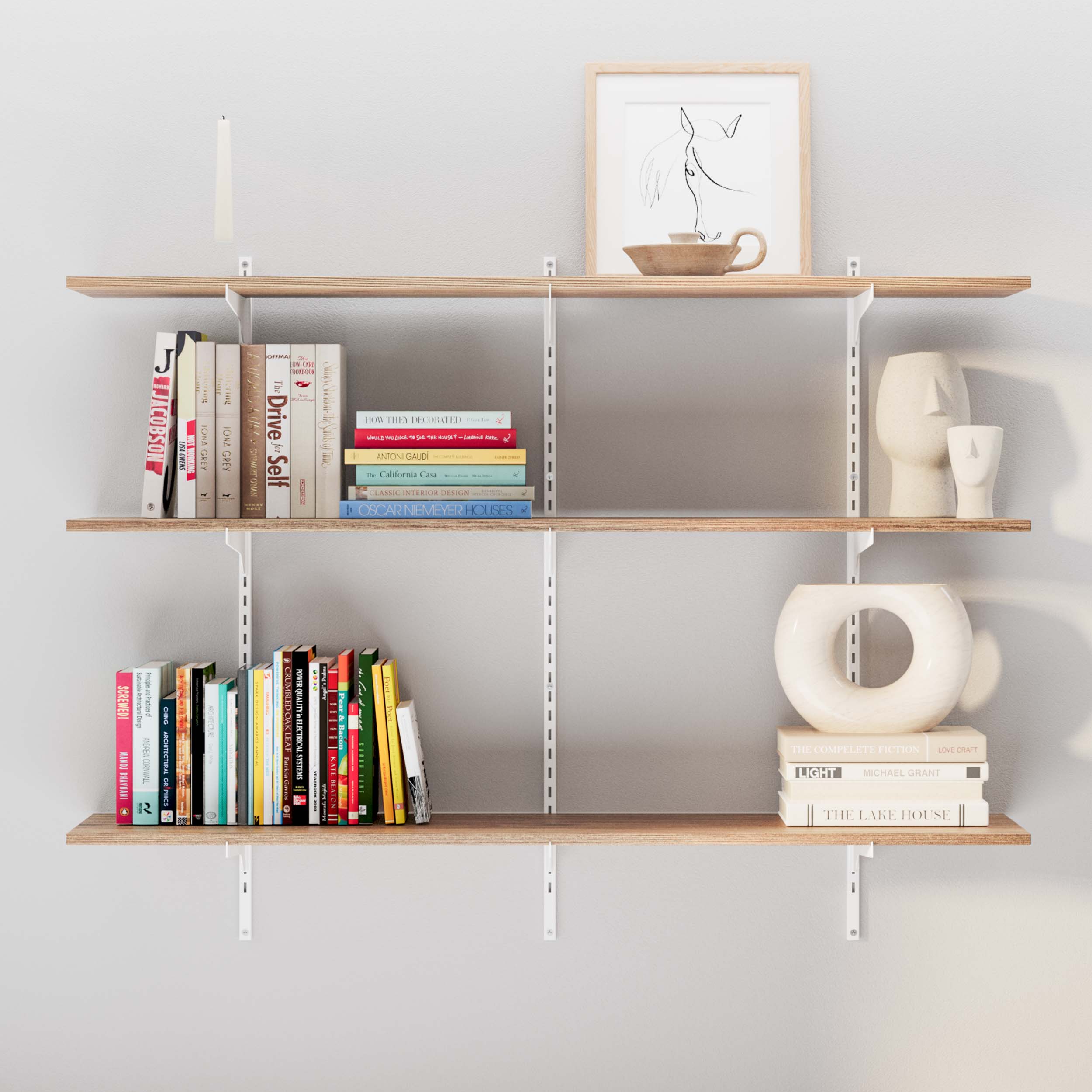 Wooden shelves arranged with an eclectic mix of books, framed art, and modern pottery.