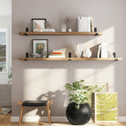 Two wooden floating shelves with different length options styled with books, decor items, and minimalistic frames. A modern, airy setup with natural light, emphasizing simplicity and functionality.