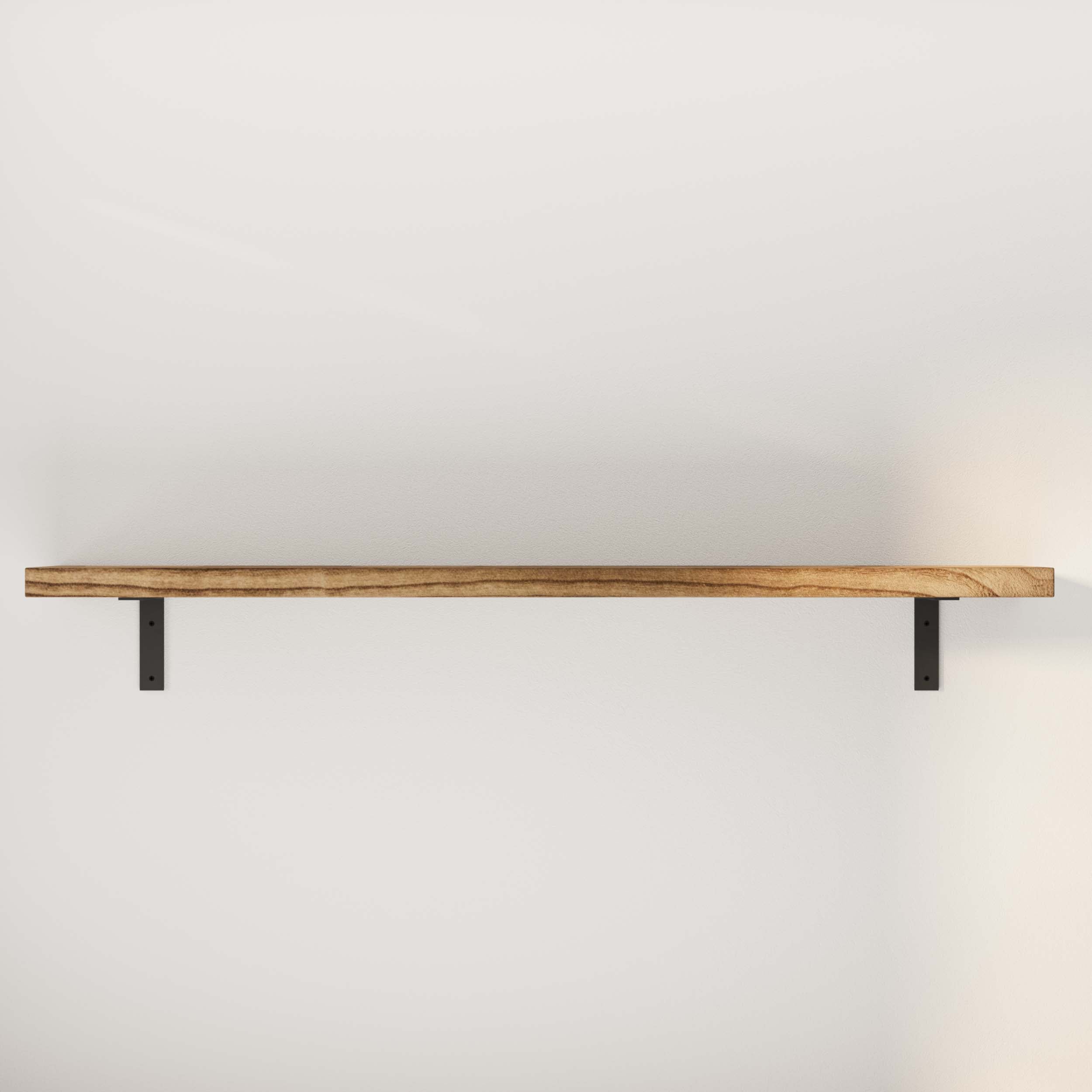 An organizer shelf on a white wall, supported by two black brackets, with a soft shadow beneath it.
