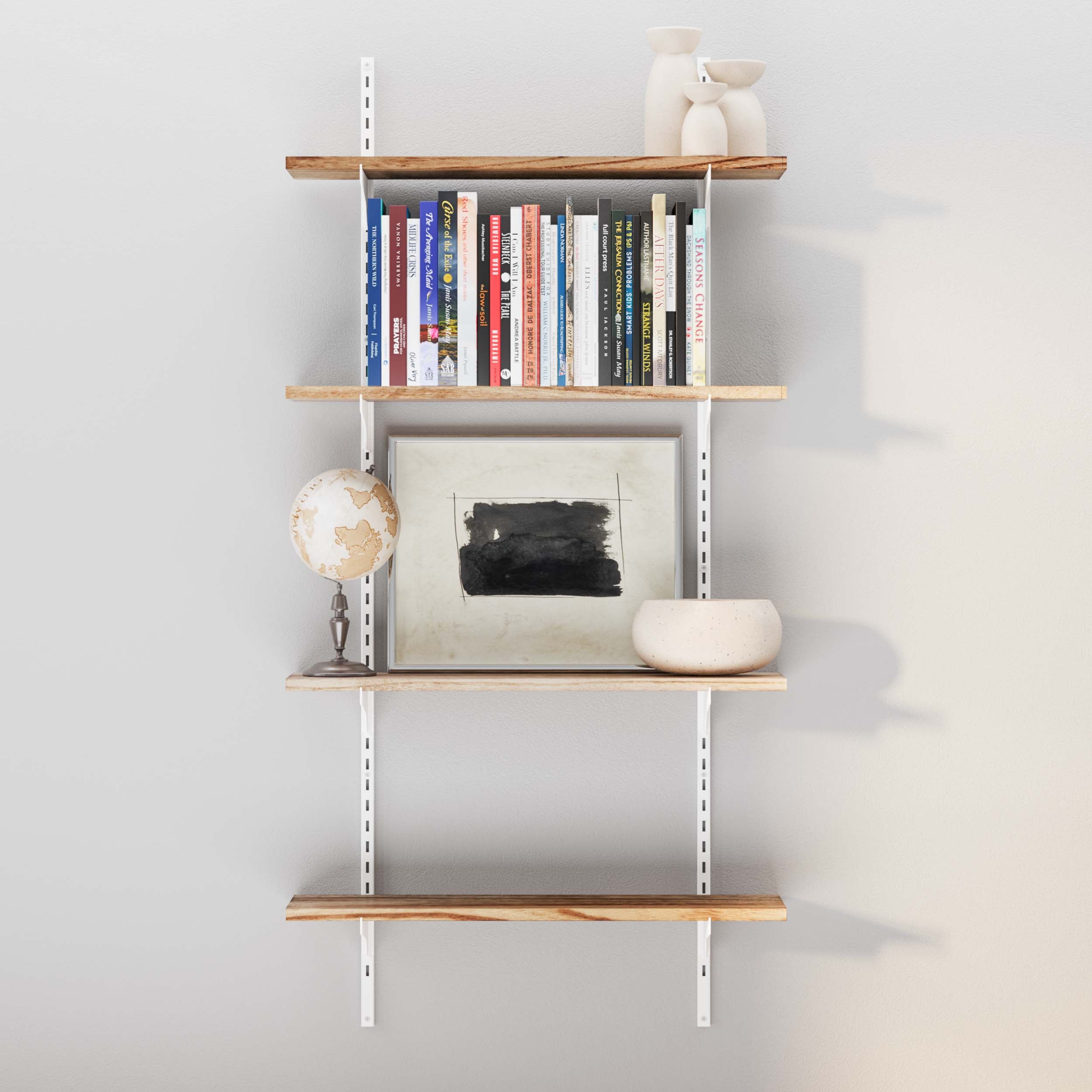 A full view of the adjustable shelves with books and decorative items on a grey wall.