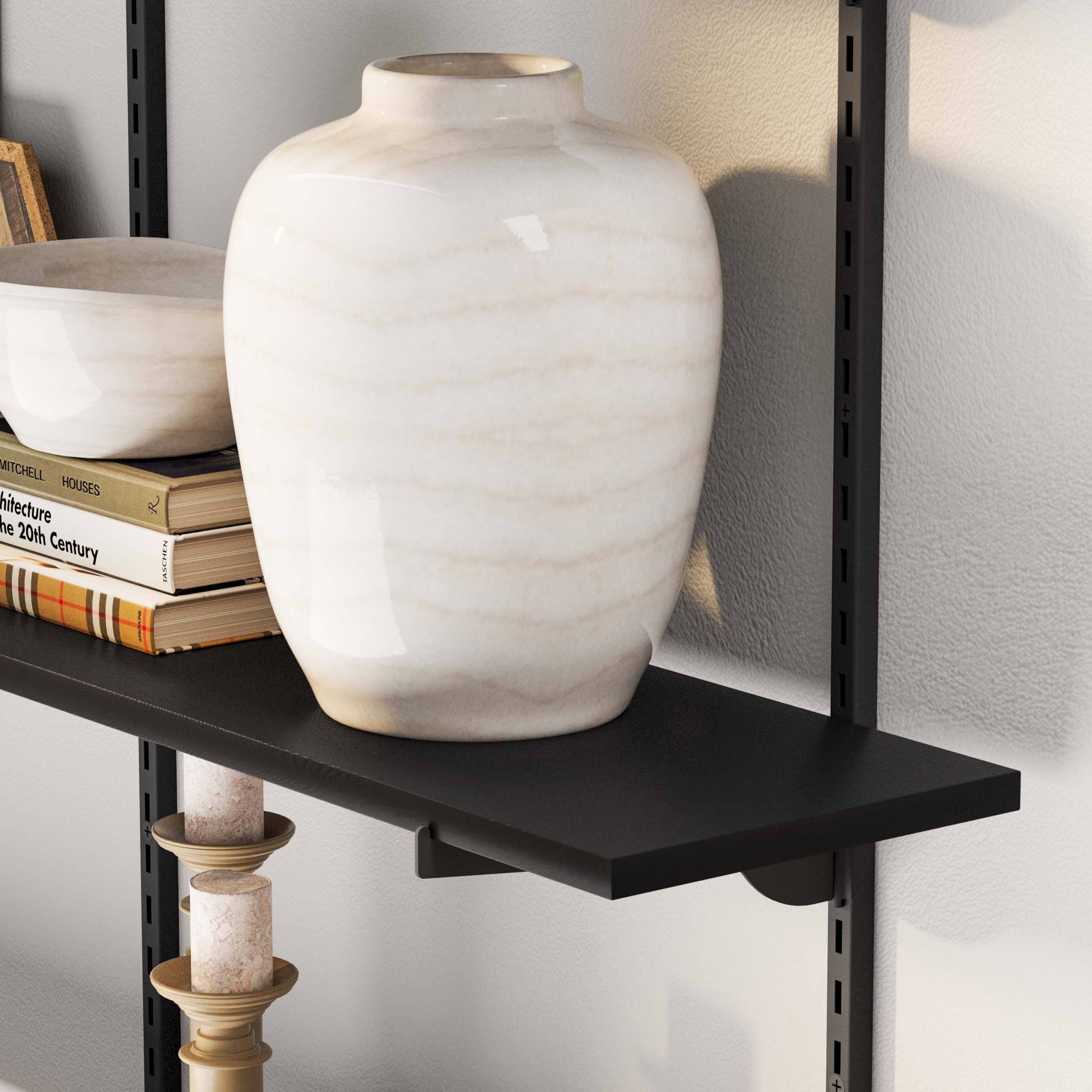Close-up of black wall shelf with books and elegant white vase, clean and sophisticated look.
