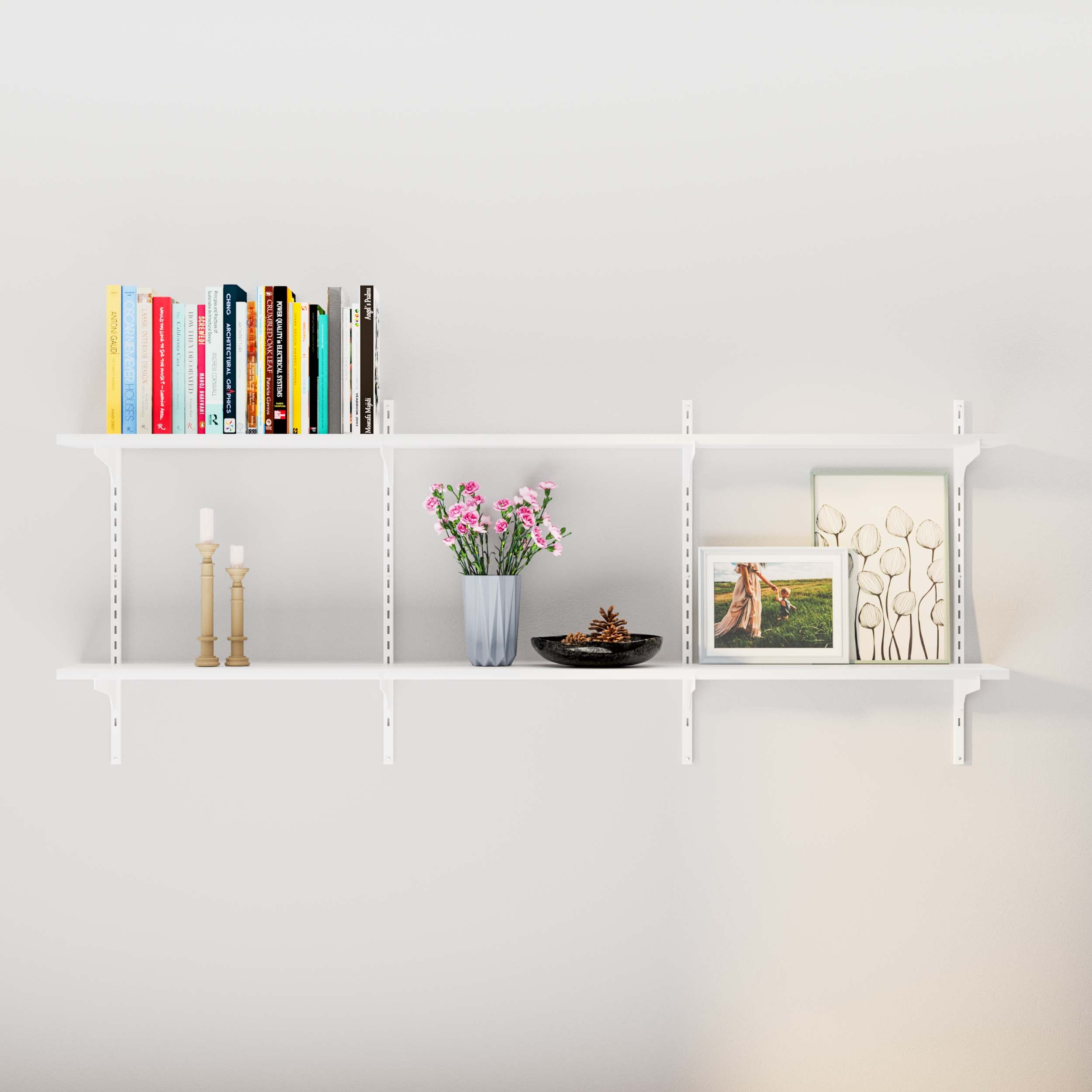 White floating shelves adorned with books, flowers in a vase, and art prints, creating a cozy nook.