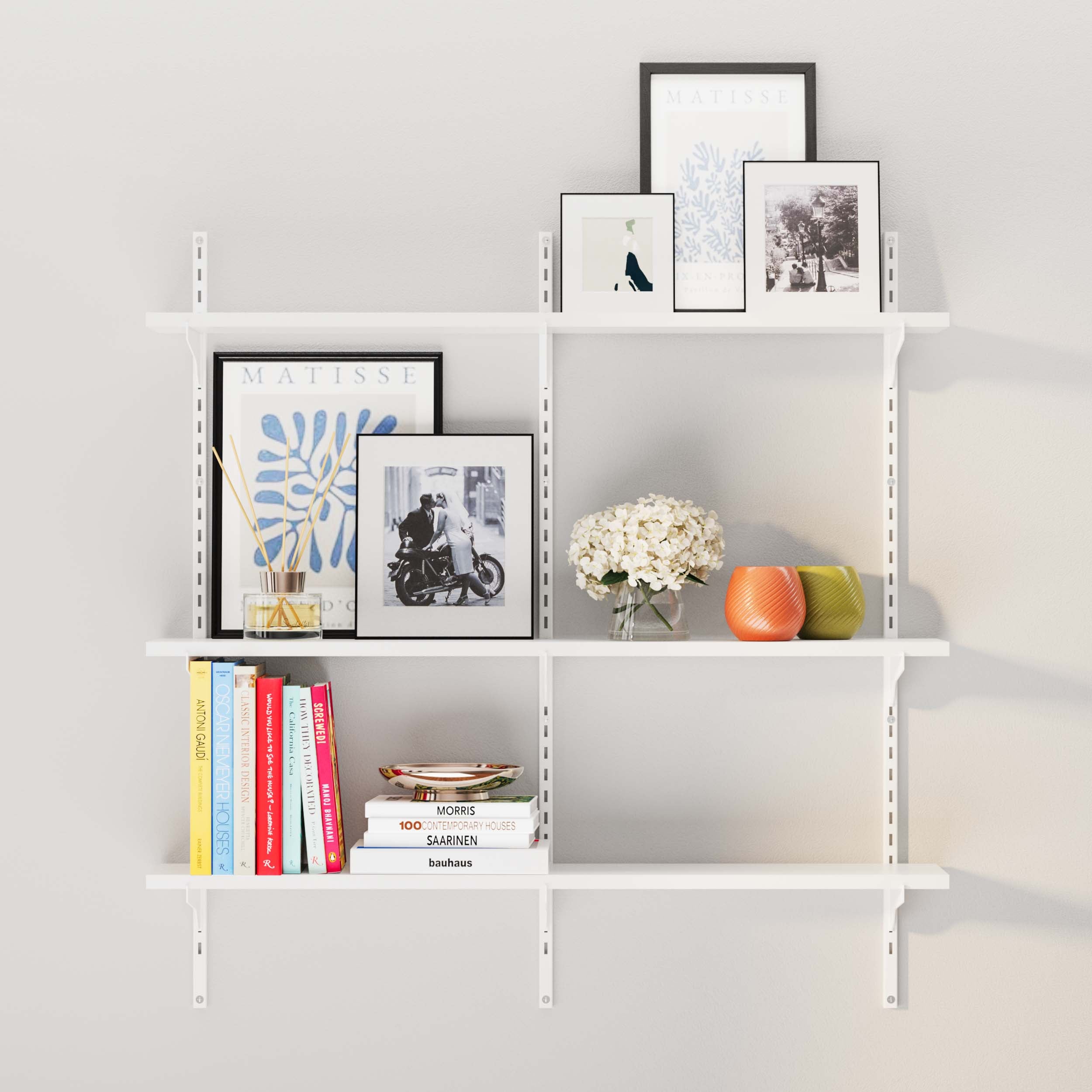 Wall shelves white with framed art, books, and decorative items against a light wall.
