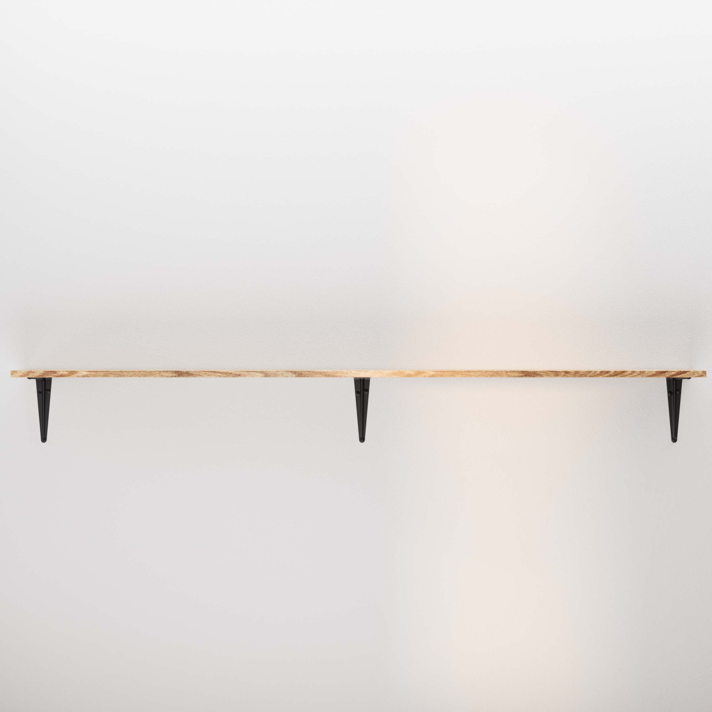An empty wooden shelf supported by two black brackets, presenting a clean and minimalistic look against a white wall.