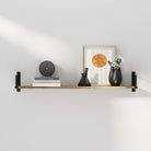 Heavy duty shelf burnt color featuring a clock, black vases, books under a graphic print, in a bright and modern setting.
