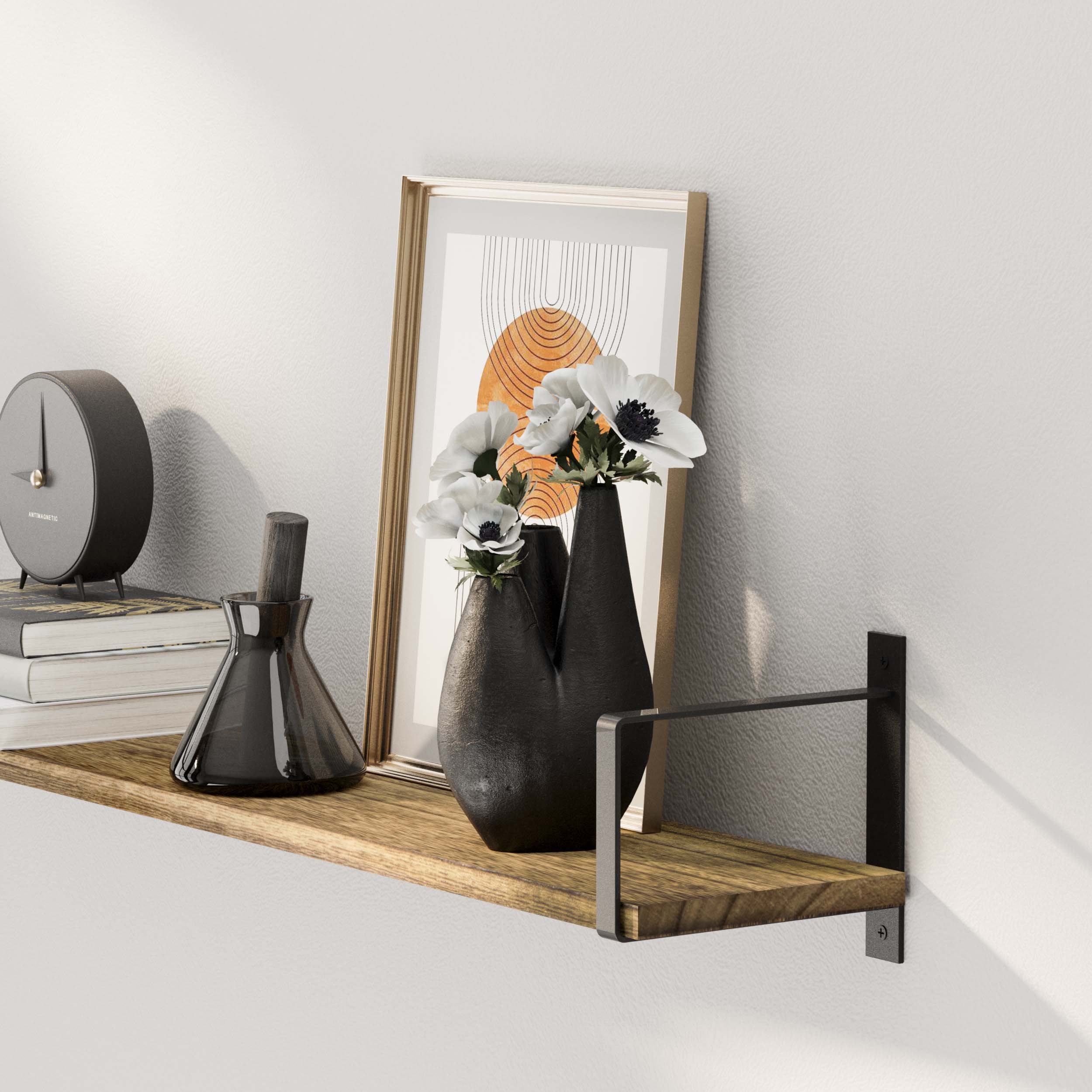 Wall shelf burnt with black vases and a framed abstract print, under soft lighting, creating a serene ambiance.