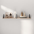 Simple wood shelf displaying a blend of books and decorative art.