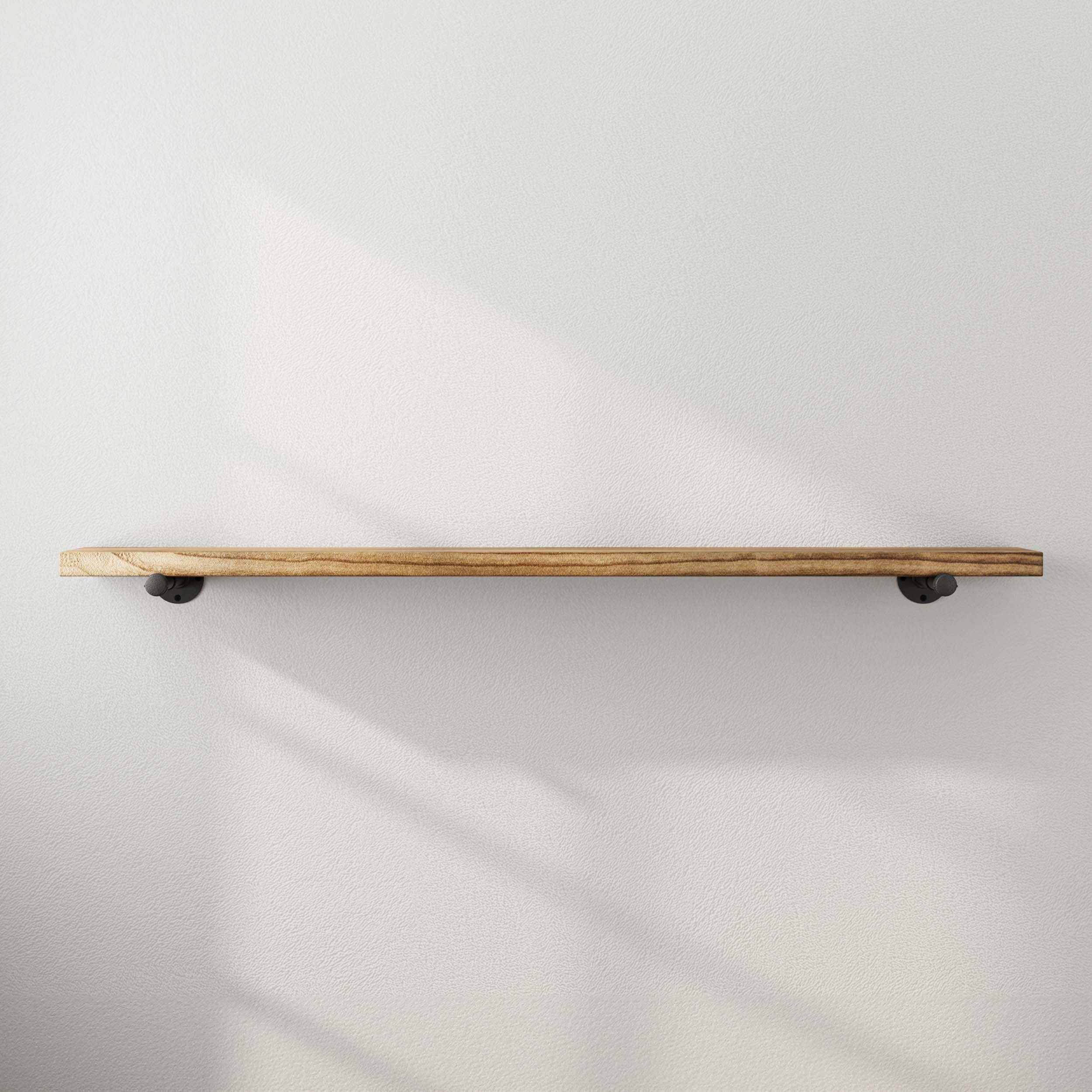 A minimalist floating shelf mounted on a white wall, showcasing its natural wood finish and sturdy pipe bracket support.