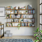 A multi-tier long shelving unit filled with books, decor items, and greenery in a home library setup, emphasizing organization and utility.