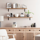 Two wooden floating shelves with different length options styled with books, decor items, and a minimalistic frame. A modern, airy setup with natural light, emphasizing simplicity and functionality.