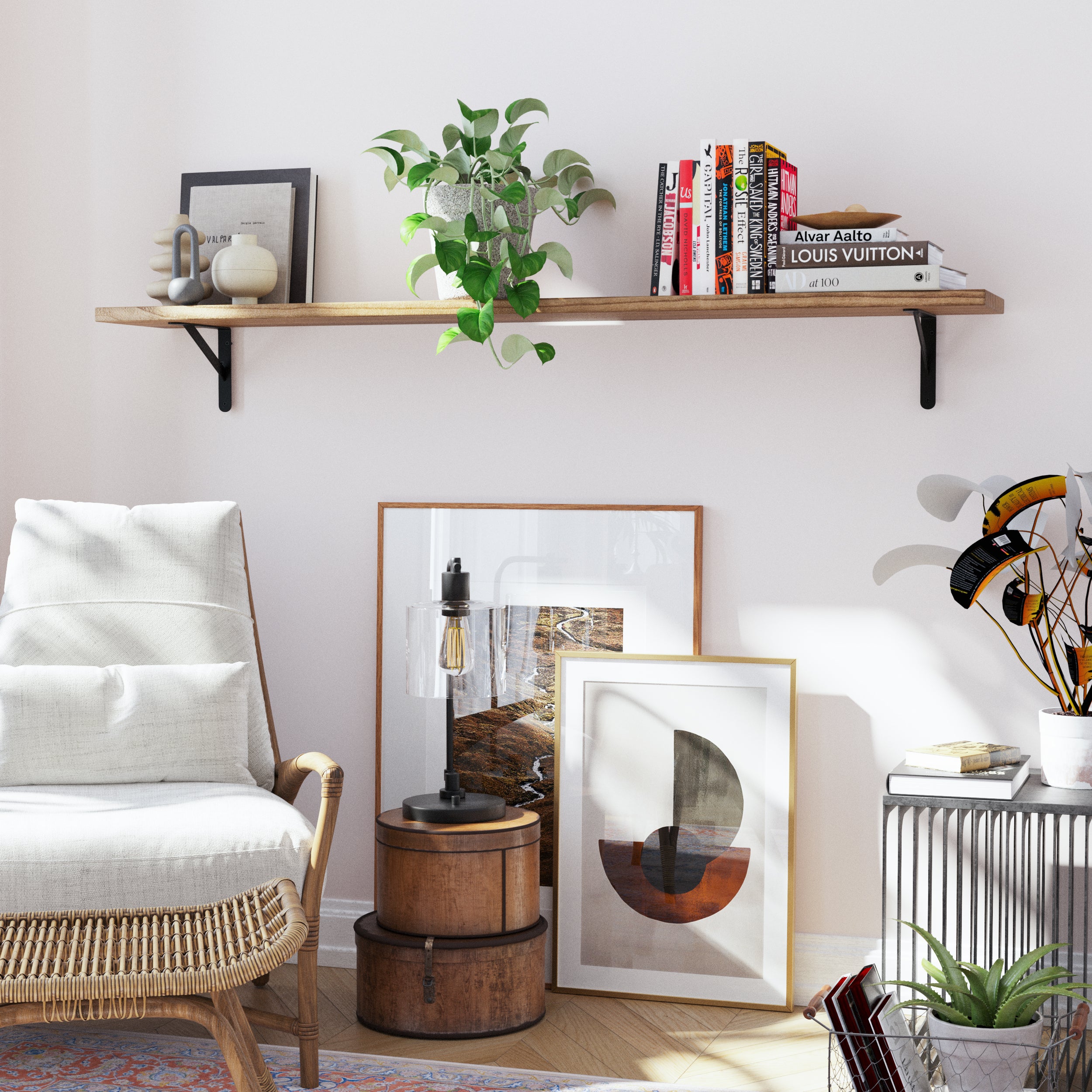 A single wood long shelf in rich burnt finish over beautiful picture frames, styled with books, and lush green plants, creating an organized workspace.