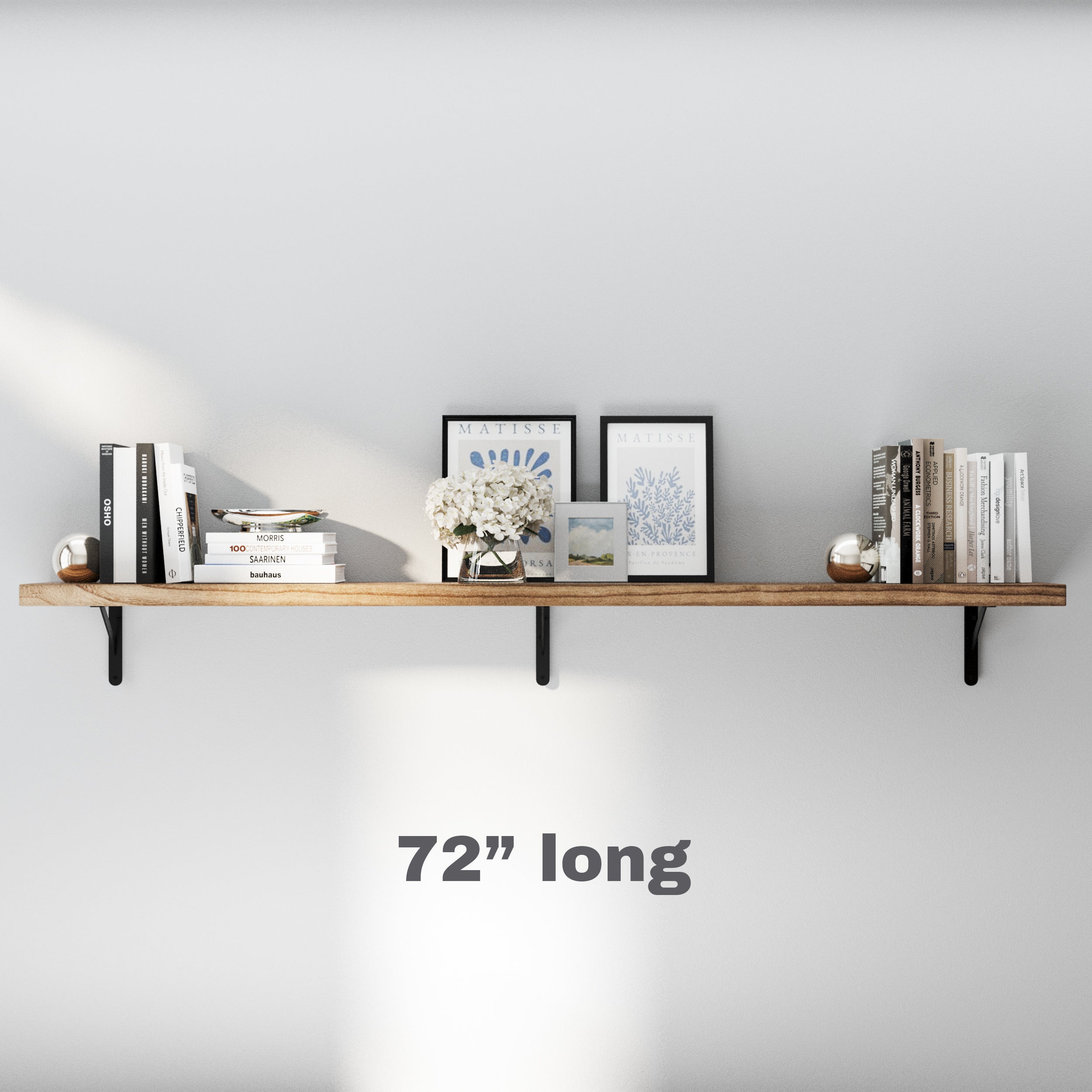 A minimalist 72 inch extra long floating shelf with black metal brackets. Styled with Matisse artwork, books, and decor, blending elegance and functionality for living spaces.