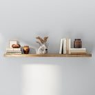 A thick hidden bracket shelf in a rustic wood tone is styled with neutral-toned books, sculptural vases, and dried florals in a ceramic vase. A minimal setup that combines texture and simplicity for a modern aesthetic.
