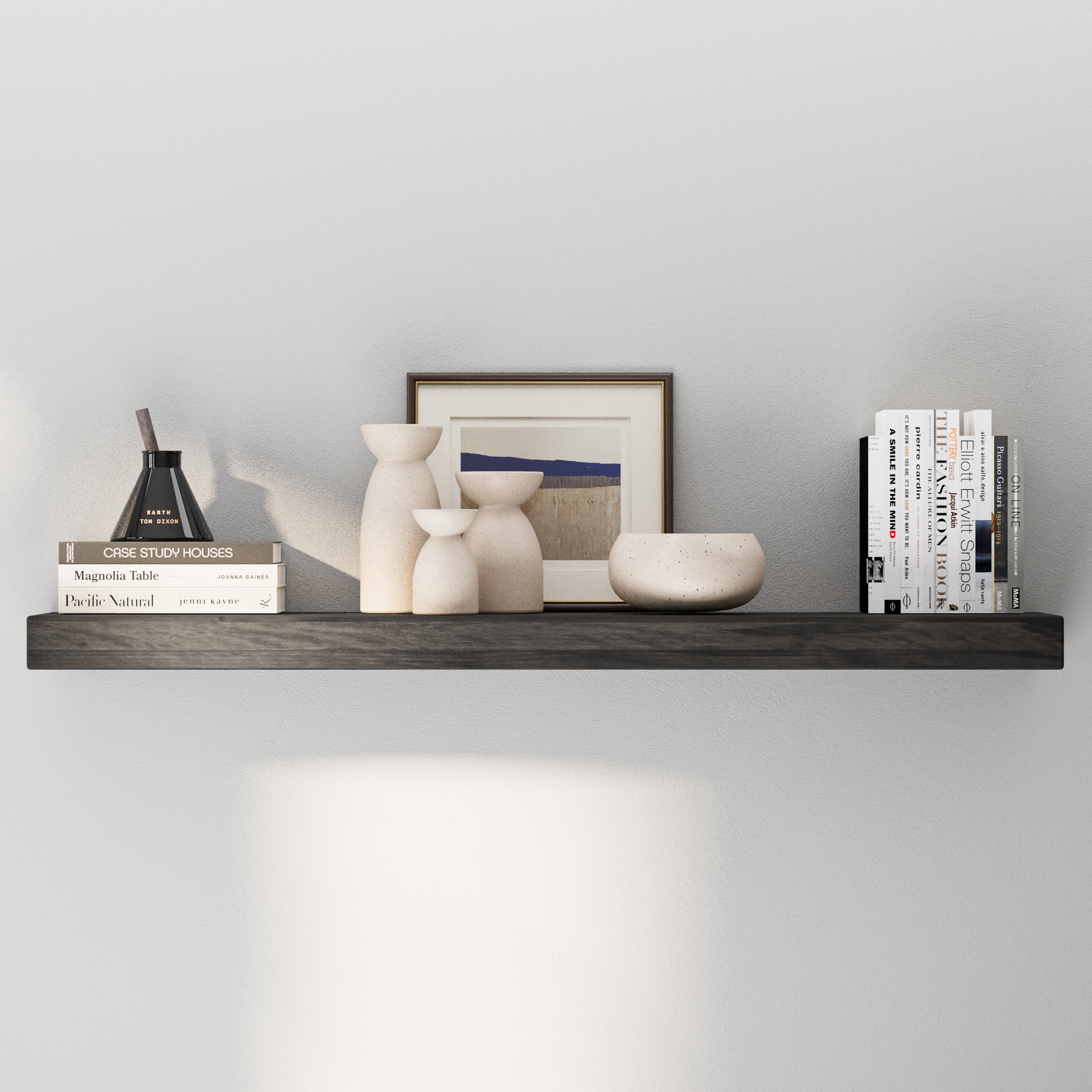A floating shelf in a rich ebony finish, decorated with neutral-toned vases, a framed print, and books. Minimalist yet warm design ideal for modern living spaces.