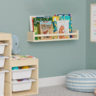 A natural wood book shelf for kids room in a children's room, filled with books. Mounted on a mint green wall above a storage unit with bins and toys, creating an organized and playful environment.