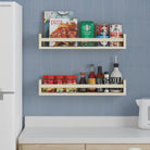Two natural wood floating shelves for kitchen in a kitchen setting, holding cookbooks, spices, and condiments. Positioned on a blue tiled wall above a countertop, providing practical and stylish storage.