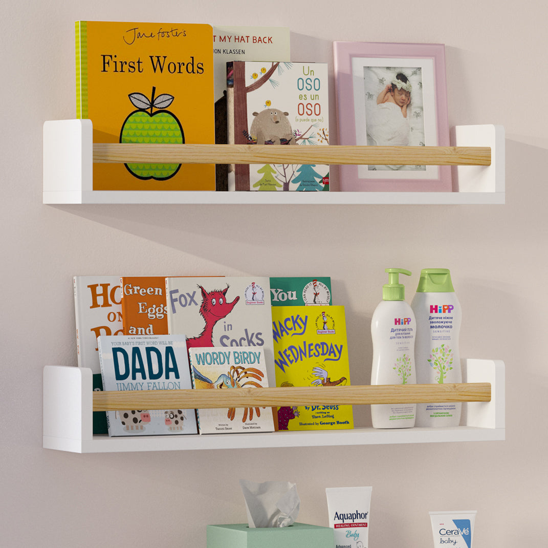 Two white floating bookshelves for kids room with natural wood rods filled with children's books, baby care products, and a framed photo. Mounted on a soft pink wall in a nursery, creating a charming and organized space.