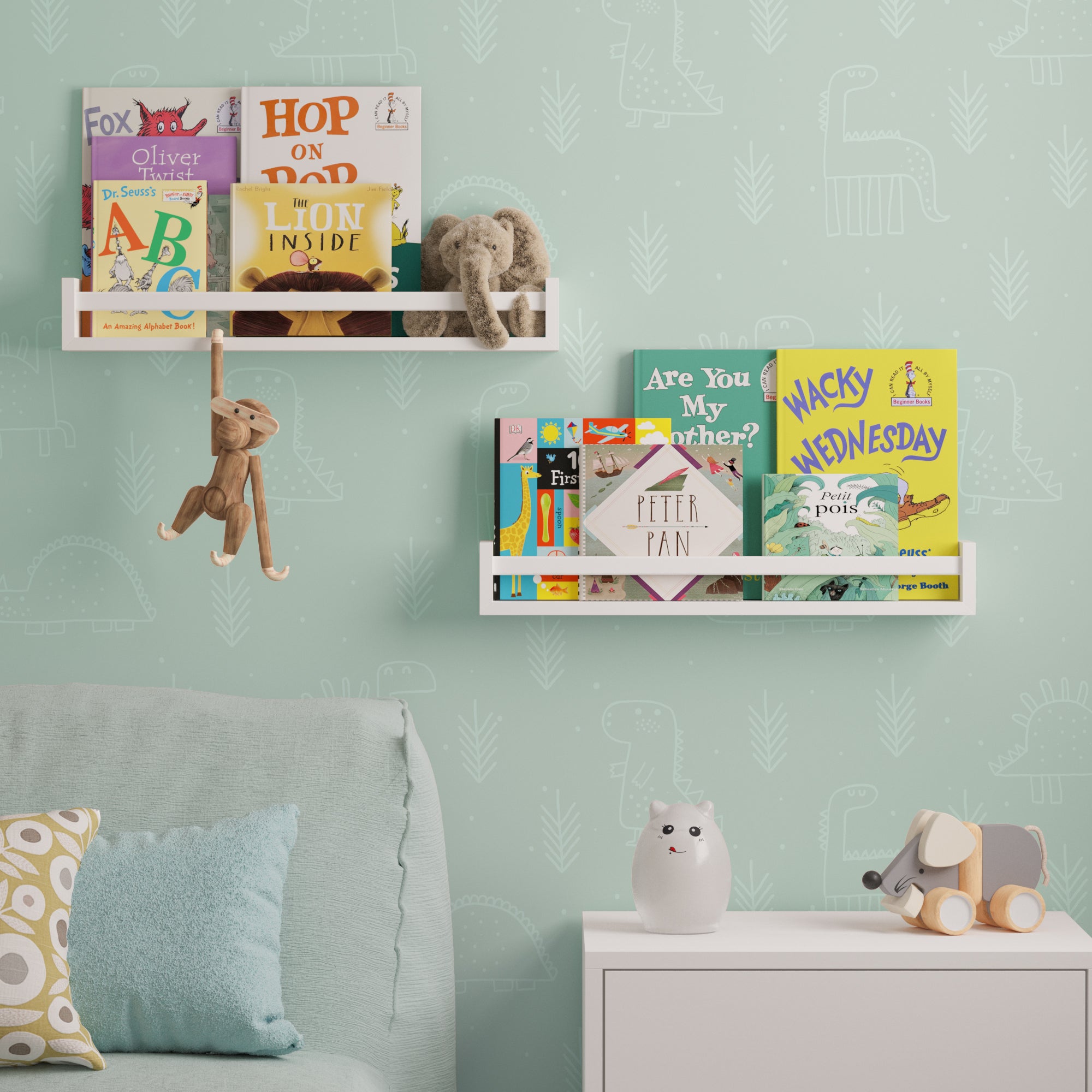 Two white wall mount nursery shelves on a light green wall, holding children's books and plush toys, with a playful wooden monkey hanging from one shelf, creating a charming, organized reading nook.