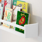 A close-up of the white floating shelf nursery is displayed with various children's books, showcasing its suitability for a nursery or kids' room.