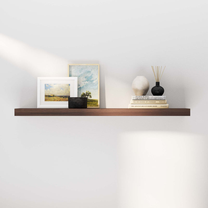 A book shelf walnut displaying books, an art frame, and a decorative vase with reed diffusers, enhancing a modern and minimalistic living space.