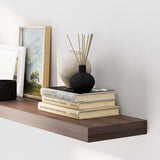 Minimalist wall storage shelf elegantly displaying an art frame, a vase, and neatly stacked books, contributing to a serene and organized look.