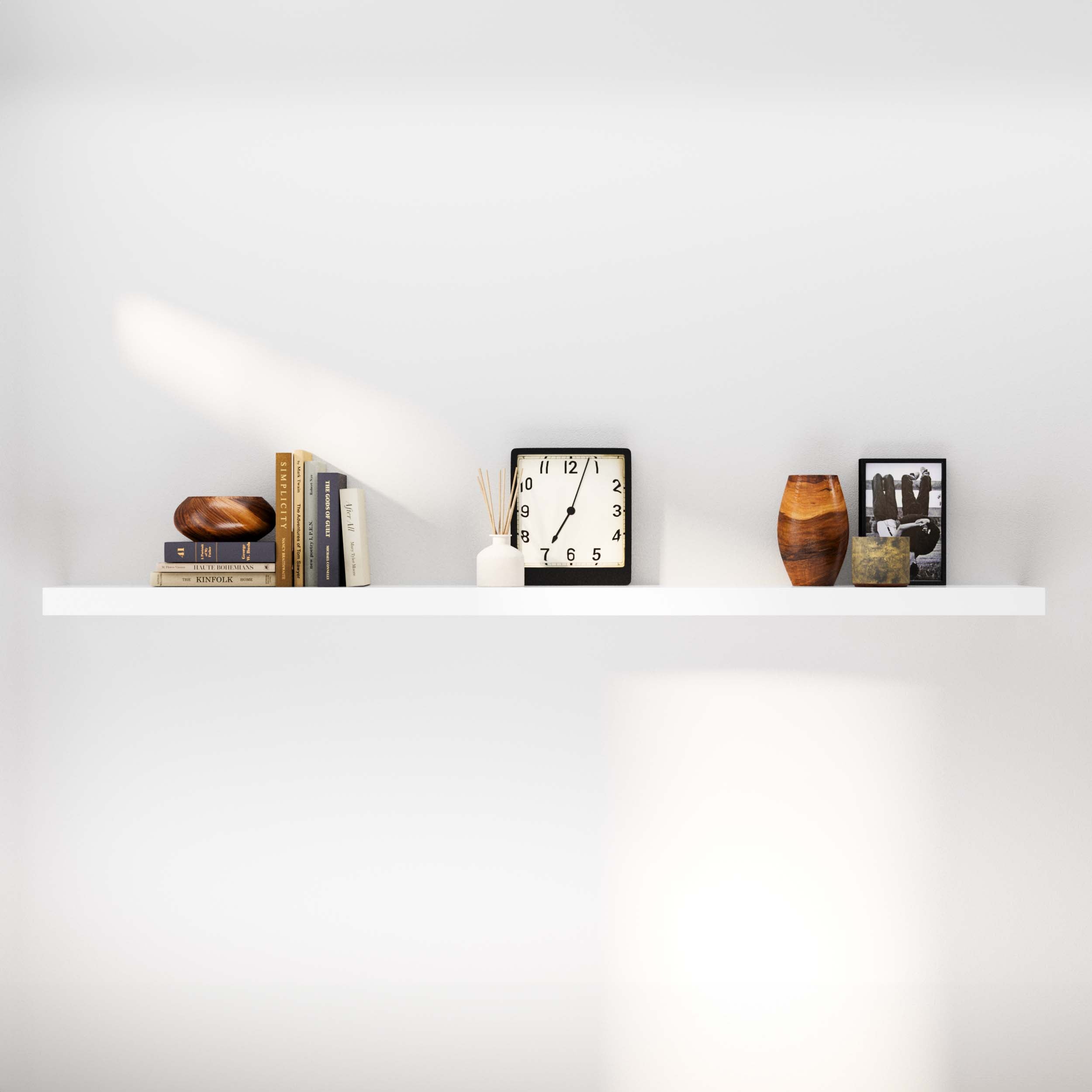 Stylish shelving unit white arranged with books, a clock, vases, and a framed picture.