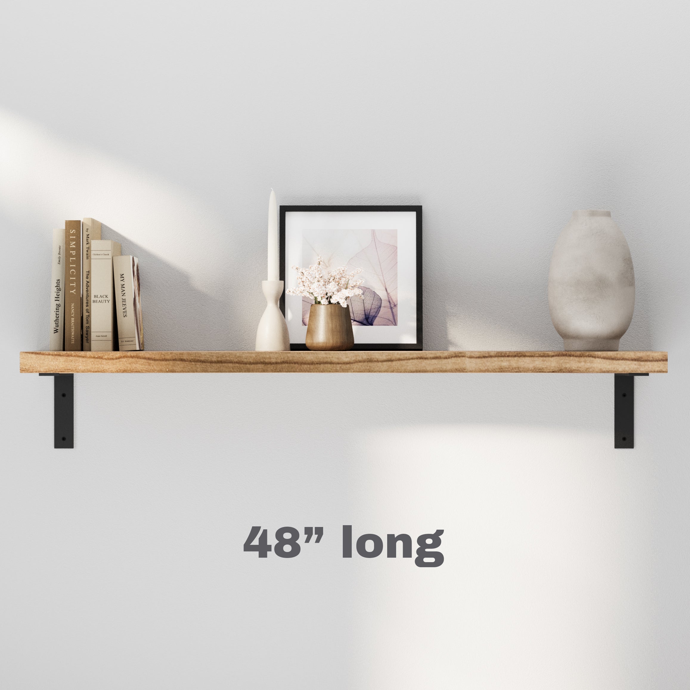 A single minimalist wooden shelf with black brackets, neatly styled with books and small decorative pieces, enhancing any wall space effortlessly.