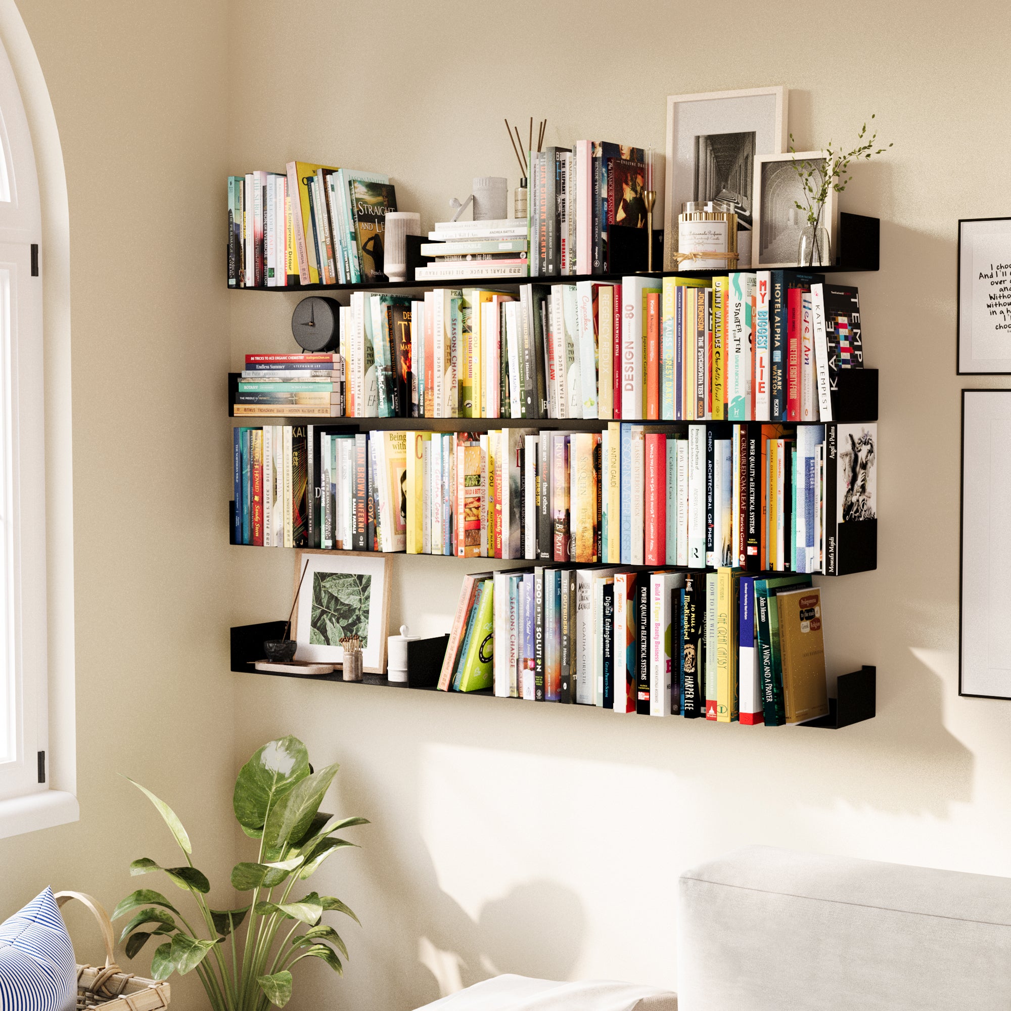 A wall-mounted black bookshelf setup with multiple metal floating shelves, densely filled with books and small decor, creating a compact and stylish library corner in a living space.