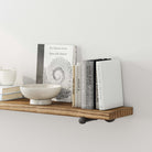 A close-up of the shelf displaying books and a decorative bowl, highlighting its ample space for organizing small items.