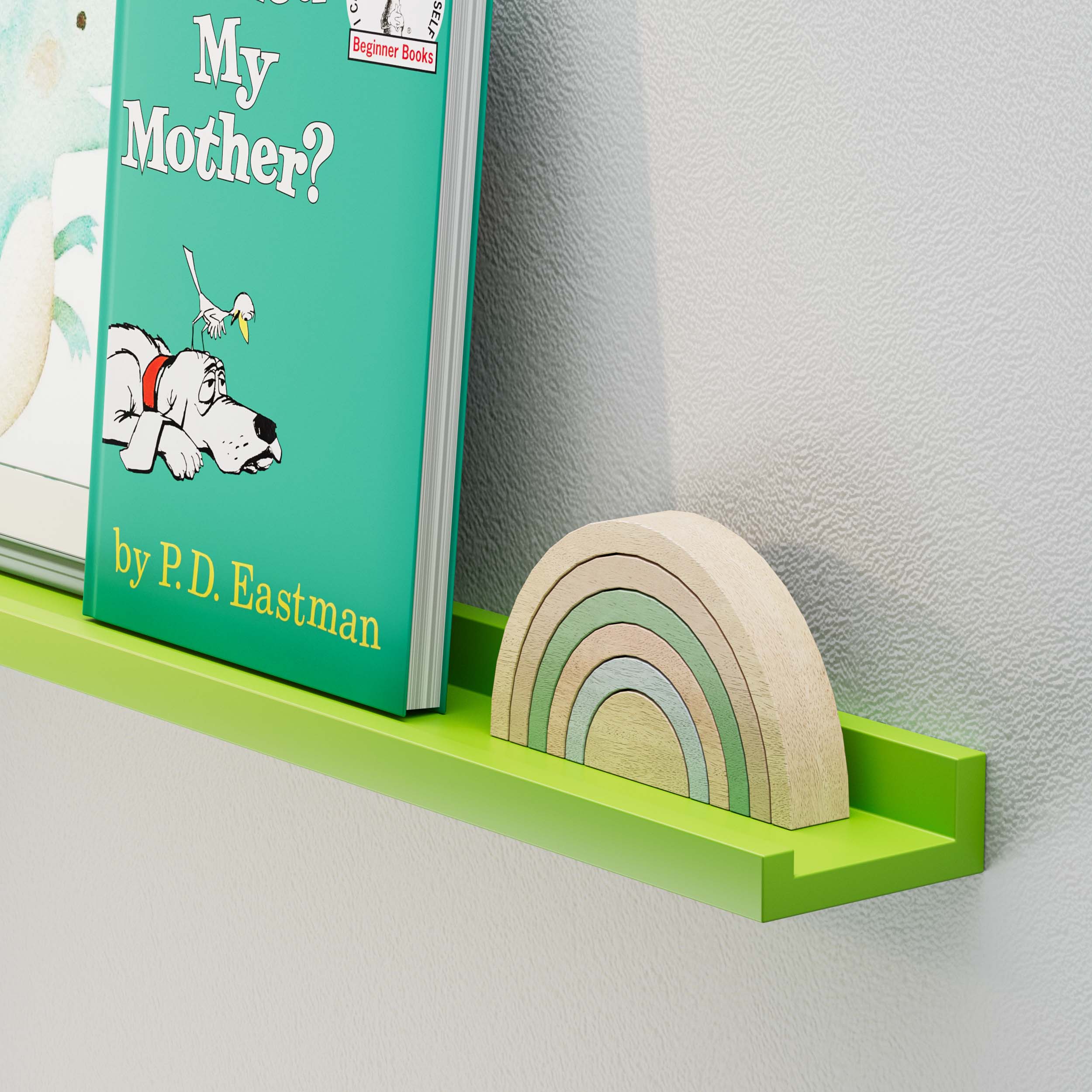 Jungle Green" floating kids shelf styled with a children's book titled "Are You My Mother?" by P.D. Eastman, along with a small, decorative wooden rainbow toy. This setup provides an example of how the shelf can be used to organize or display books and toys, making it both a functional and aesthetically pleasing addition to a room.