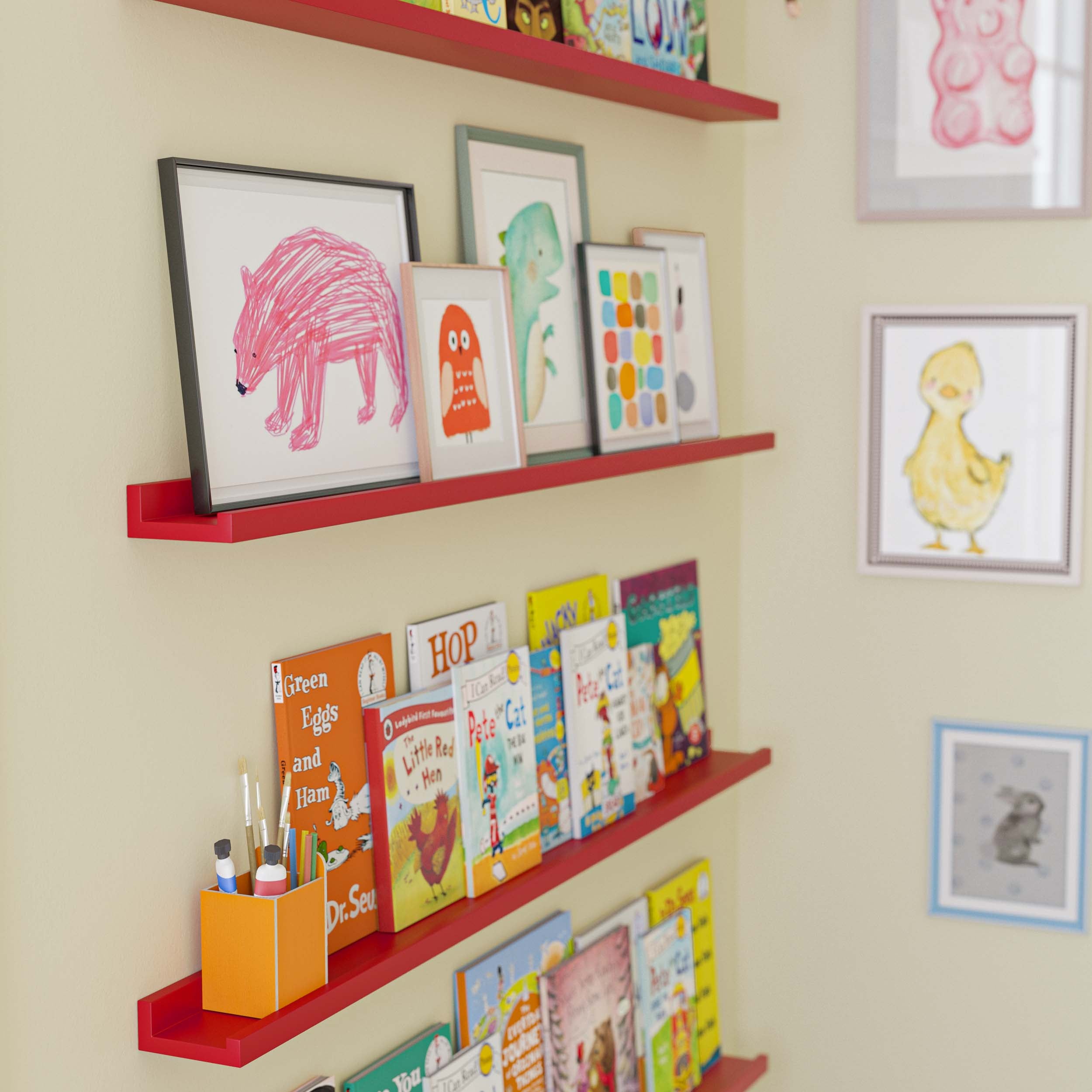 three red wall-mounted shelves filled with children's books in a playful and organized children's room, with additional decor like toys and a wooden block toy on the floor, enhancing the room's lively atmosphere.