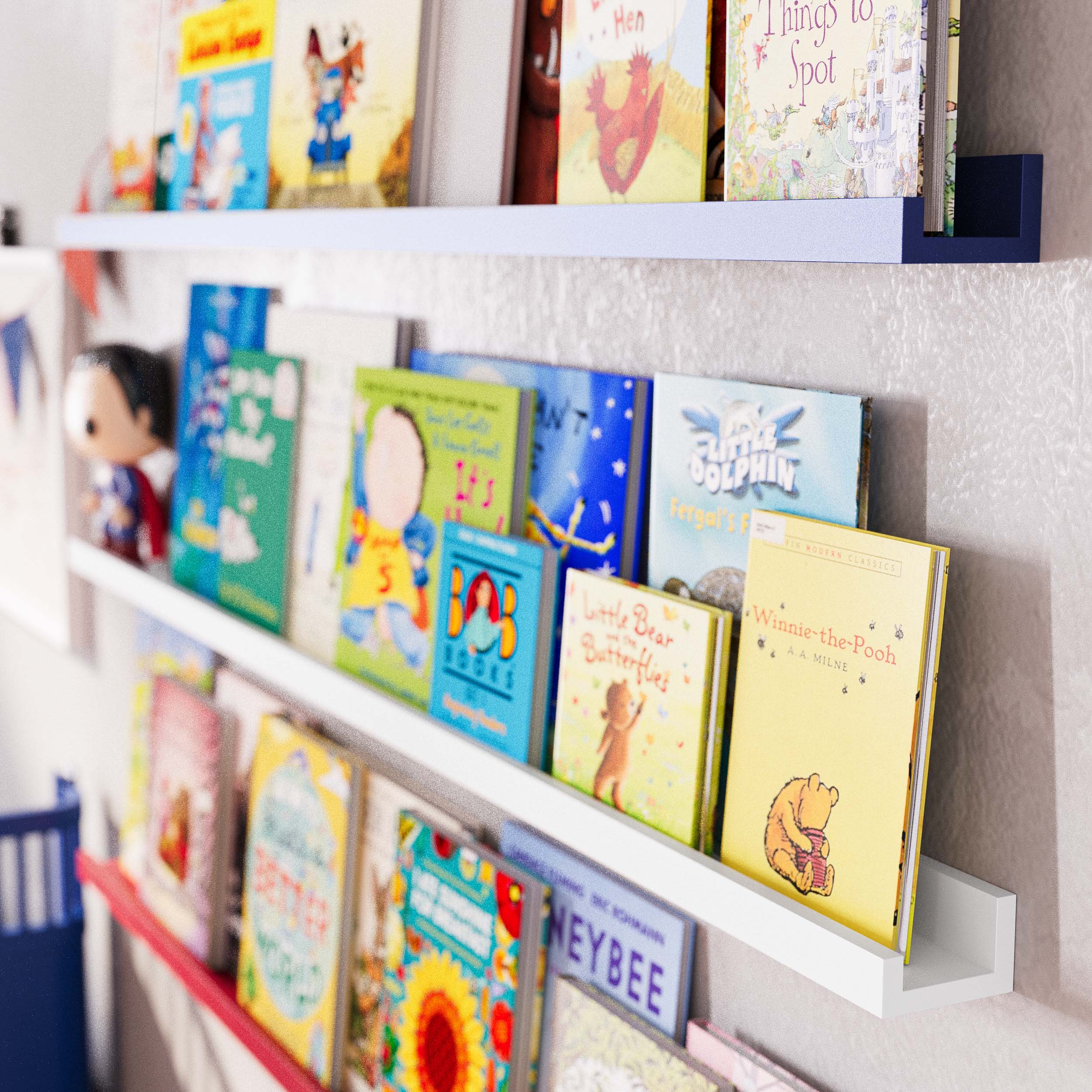 Books arranged on the long kids shelves from a side angle, emphasizing the neat and accessible organization. The focus is on the simplicity and practicality of the nursery shelving, which allows children easy access to their books and toys.