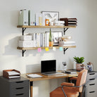 A workspace setup with two office organizer shelves stacked above a desk, displaying books, office supplies, and plants. The black brackets provide a modern industrial touch, blending functionality with style.