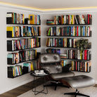 A cozy reading corner with multiple black metal shelves filled with books, accompanied by a modern leather chair and ottoman, creating an inviting, stylish library space.