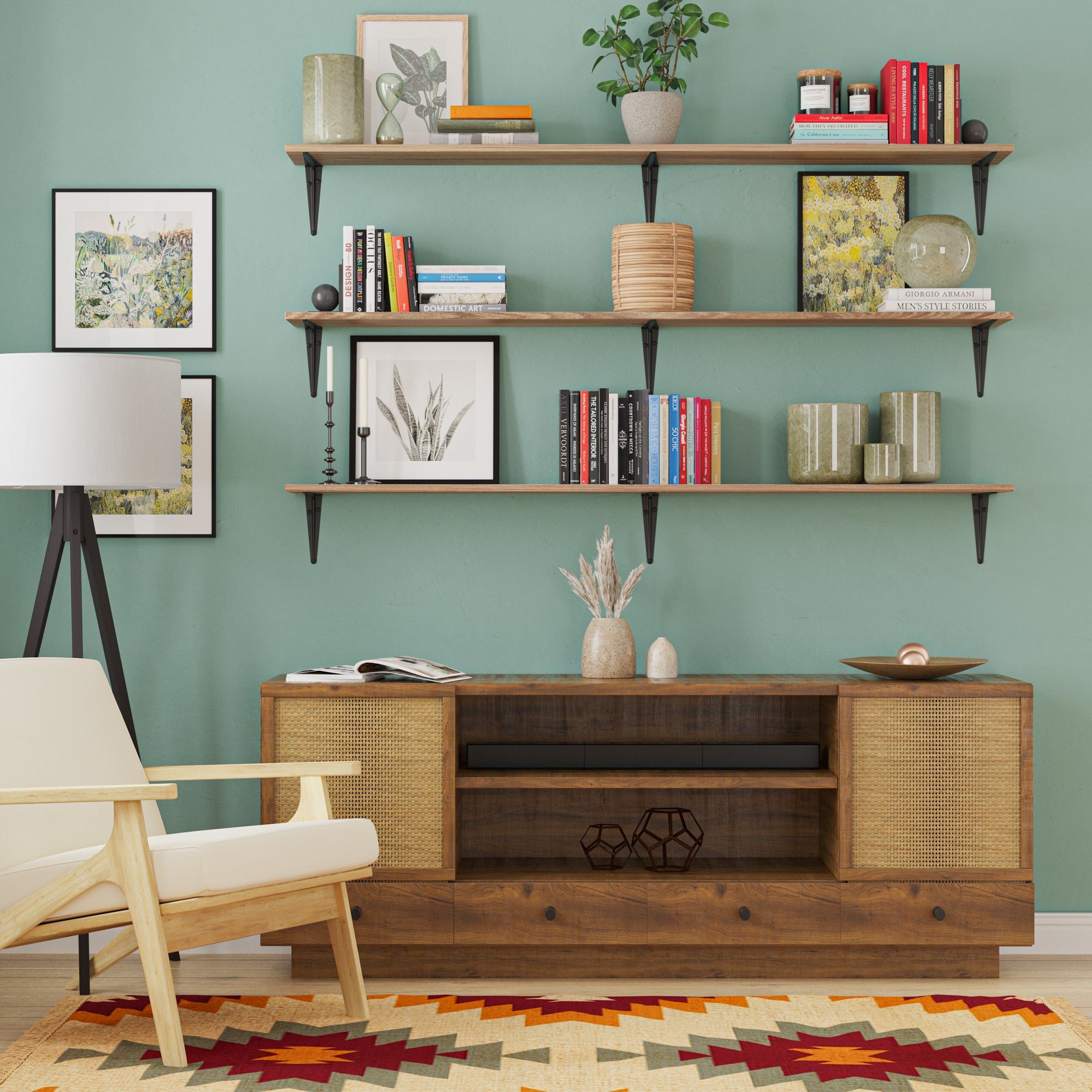 A stylish living room setup with three wooden shelves filled with colorful books, framed art, and earthy-toned vases against a green wall—perfectly balanced above a wooden media console.
