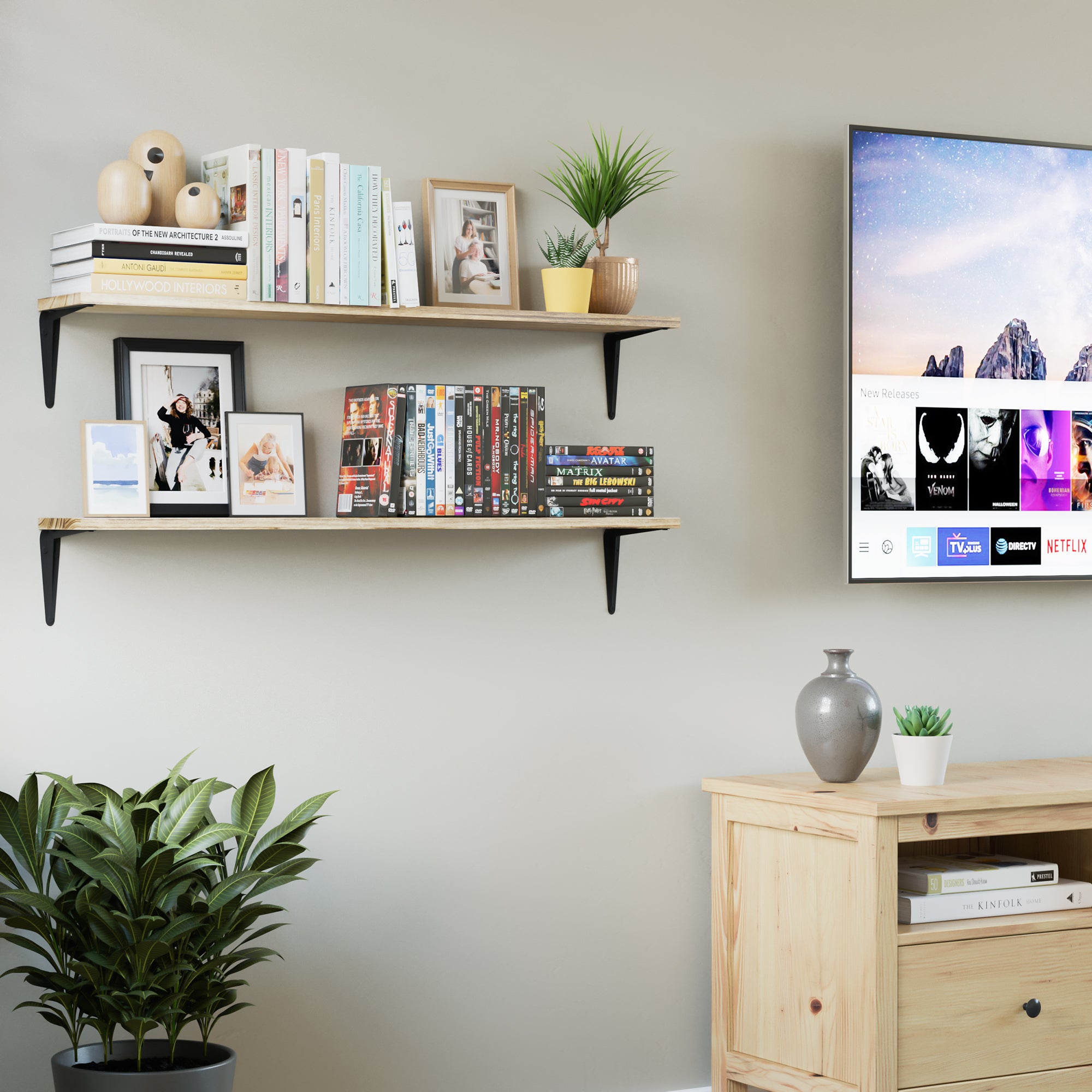 Two floating wood shelves beside a TV, holding books, framed photos, and decorative plants. A smart storage solution for living or media rooms.