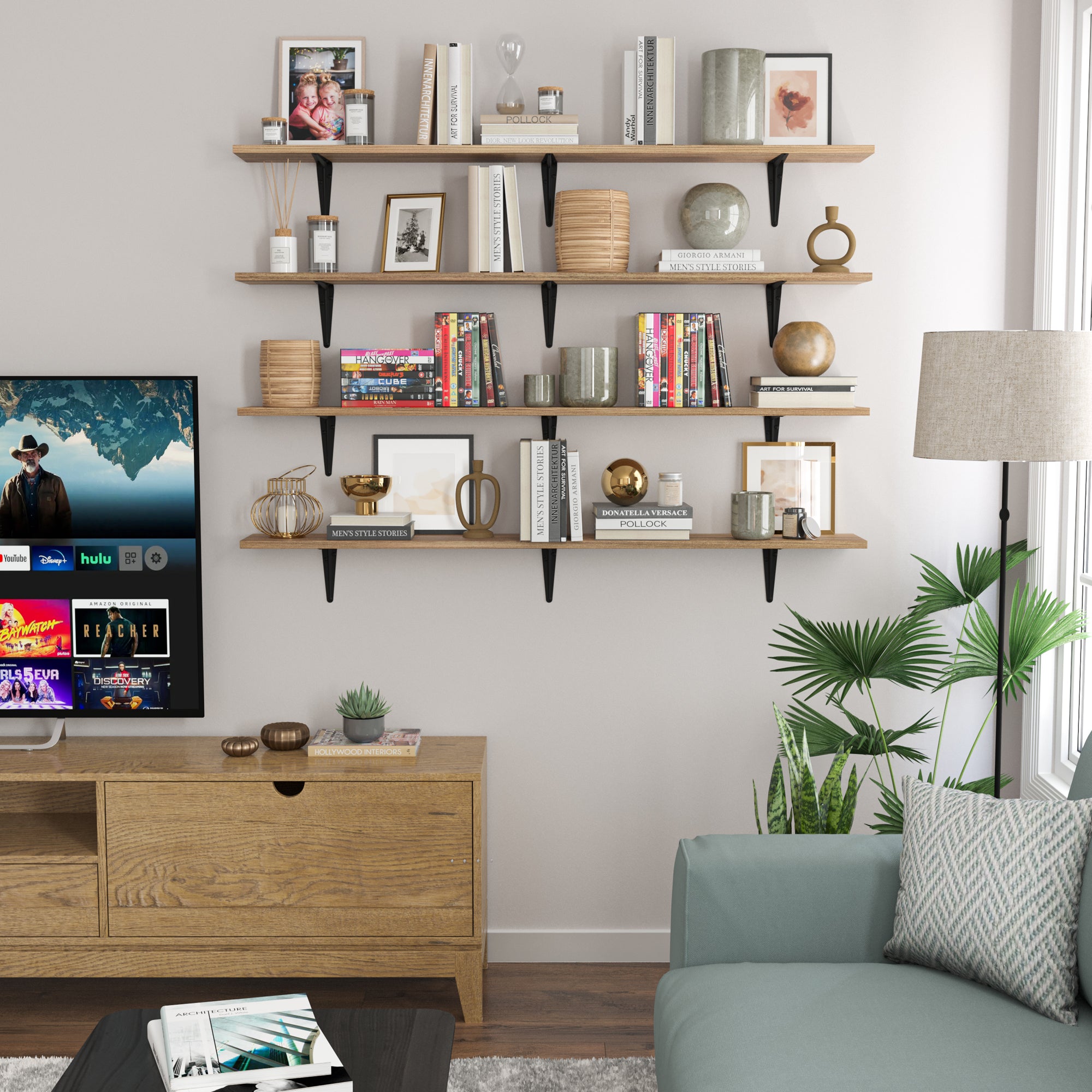 A stylish living room setup with wood floating shelves above a TV displaying trinkets, books, and decorative items, complemented by a modern sofa, side table, and an elegant floor lamp.
