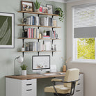 A home office wall with four floating office shelves above a desk. Books, plants, and framed prints offer both function and style for a productive workspace.