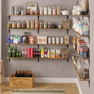 Well-organized pantry display with wall-mounted wooden shelves holding dry goods, beverages, jars, and containers. This setup maximizes vertical storage while adding rustic charm and accessibility to any kitchen or utility space.